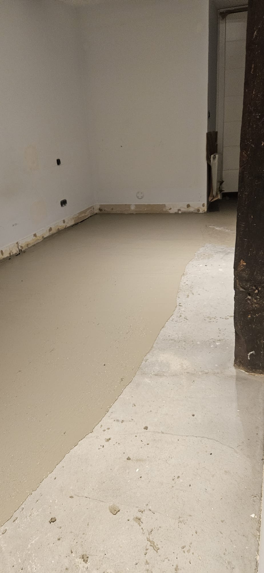 Solera de mortero autonivelante recién vertida en una habitación